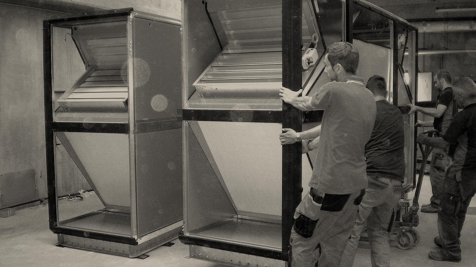 foto in bianco e nero di lavoratori Menerga mentre installano un impianto di trattamento dell'aria